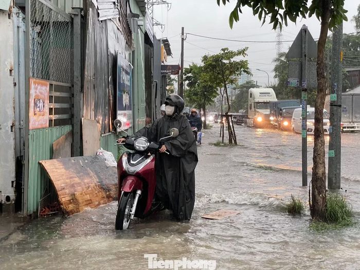 Nhiều xe máy chết máy khi cố vượt qua đoạn đường ngập, người dân phải xuống xe dắt bộ.