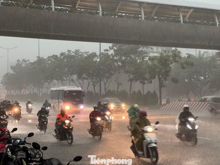 Mưa lớn, tầm nhìn bị hạn chế khiến nhiều người đi xe máy dừng trú mưa dưới gầm các cầu vượt.
