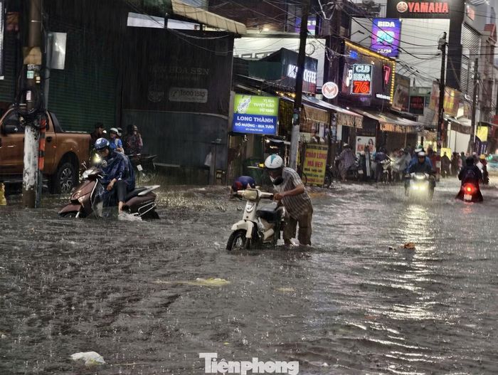 Một số phương tiện chết máy giữa dòng nước, người dân phải xuống xe, dắt bộ qua khu vực ngập.