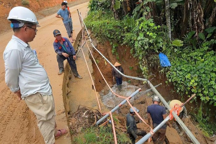 Lực lượng chức năng và đơn vị thi công gia cố điểm sạt lở taluy âm dưới chân đèo Liêu. Ảnh: T.B