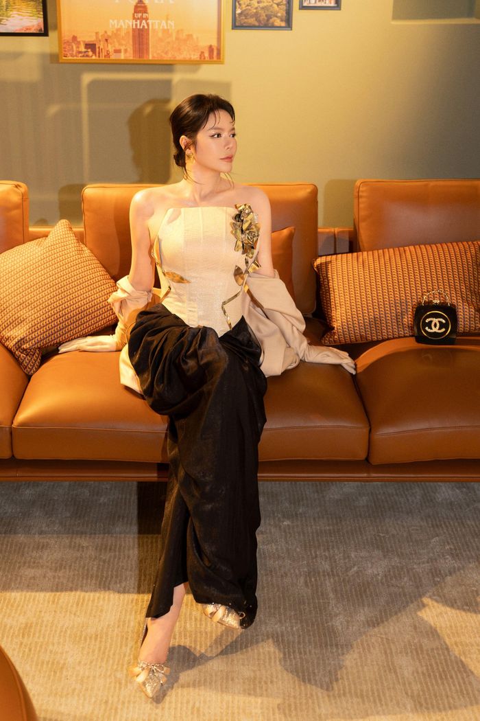 Điểm nhấn trong tạo hình là đôi găng tay opera màu beige được phối cùng phụ kiện ở phần vai và giày ánh kim. Cách kết hợp các chi tiết giúp bộ trang phục mang hơi hướng thời trang cổ điển, đồng thời phù hợp với không gian mô phỏng New York của sự kiện.