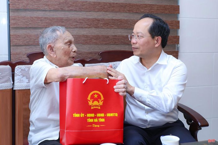 Đồng chí Nguyễn Duy Lâm - Ủy viên Trung ương Đảng, Bí thư Tỉnh ủy, Trưởng đoàn ĐBQH tỉnh thay mặt lãnh đạo tỉnh tặng quà ông Nguyễn Văn Minh.