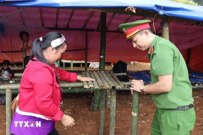 Lực lượng chức năng hỗ trợ người dân thôn Đắk Snao, xã Quảng Sơn (Lâm Đồng) ổn định sinh hoạt tại điểm sơ tán do sụt lún, sạt lở đất. (Ảnh: Nguyễn Huy Thành/TTXVN)
