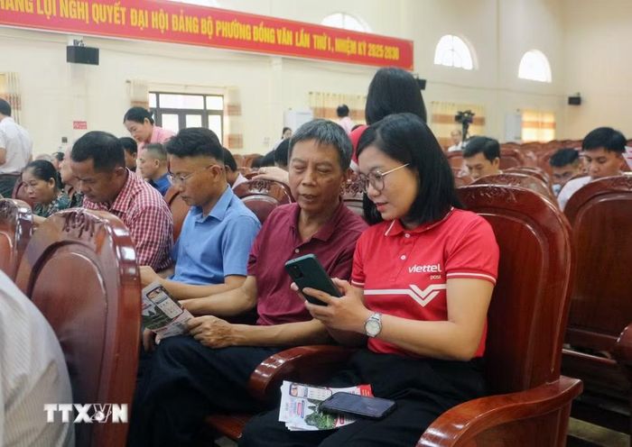 Cán bộ Viettel Ninh Bình hướng dẫn thành viên Tổ công nghệ số cộng đồng tiếp cận, sử dụng các tiện ích số. (Ảnh: Nguyễn Chinh/TTXVN)