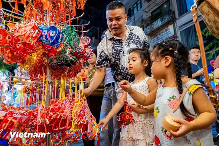 Đối với người lớn, một chuyến dạo quanh Hàng Mã còn là dịp để tìm lại ký ức tuổi thơ êm đềm giữa nhịp sống hiện đại hối hả. (Ảnh: Hoài Nam/Vietnam+)