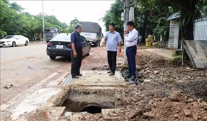 Đại diện đơn vị thi công, tư vấn giám sát trao đổi với người dân tại vị trí hố thu nước được cải tạo trên tuyến đường Tôn Đức Thắng, phường Bình Phước, thành phố Đồng Nai.