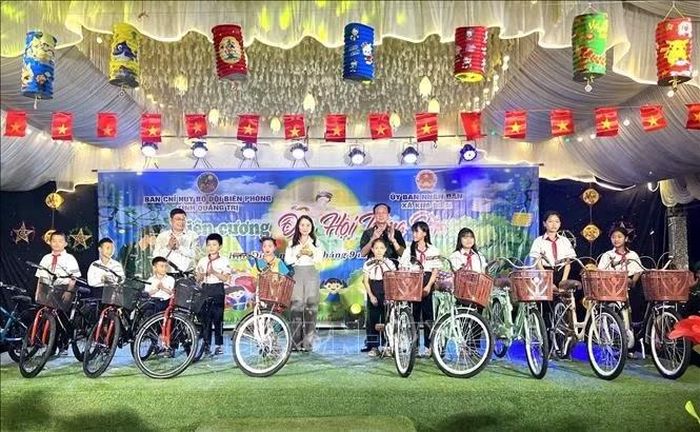 Lãnh đạo UBND tỉnh Quảng Trị tặng xe đạp cho học sinh vùng biên giới xã Kim Điền. Ảnh: Nguyên Linh/TTXVN