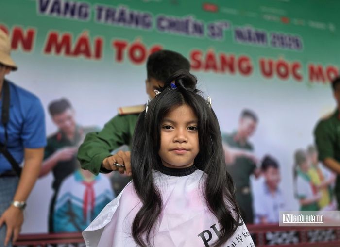 Trâm Tuyền, học sinh lớp 2 Trường Phổ thông nội trú Tiểu học và Trung học cơ sở Tây Giang, ngồi cắt tóc trong “Tiệm tóc chiến sĩ”.