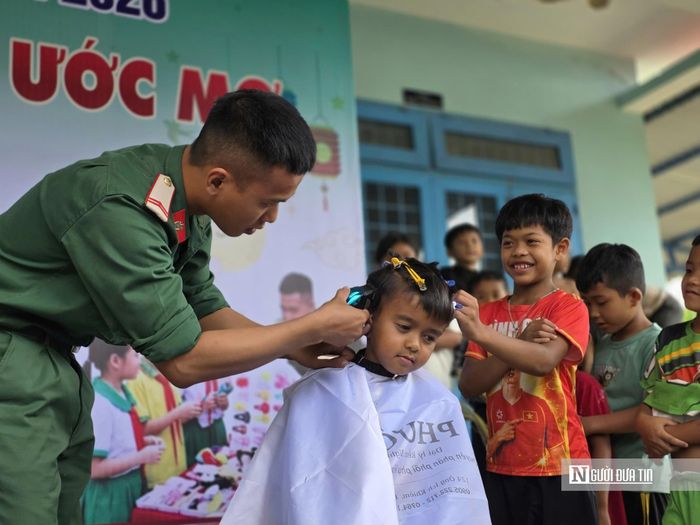 Những đứa trẻ thích thú đứng xem bạn được các chiến sĩ cắt tóc, kiên nhẫn chờ đến lượt mình.