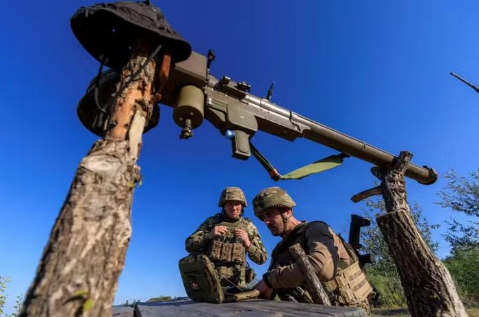 Oleksii và Vasyl đang xem máy tính bảng quân sự để theo dõi chuyển động của UAV Nga trong ca trực bảo vệ bầu trời. Ảnh: Reuters.