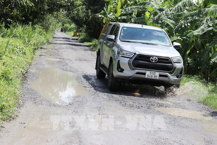 Các phương tiện gặp khó khăn khi lưu thông qua đoạn đường này. Ảnh: Hữu Chí - TTXVN 