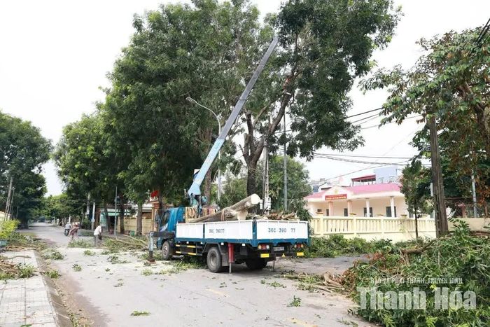 Nhân viên Trung tâm Cung ứng dịch vụ công xã Thiệu Hóa cắt tỉa cây xanh, chỉnh trang cảnh quan sau mưa lũ.
