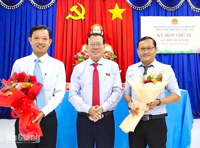 Bí thư Đảng ủy, Chủ tịch HĐND xã Bình Mỹ Nguyễn Nghi Em tặng hoa chúc mừng ông Nguyễn Văn Hiền (bên trái) và ông Nguyễn Cao Trí.