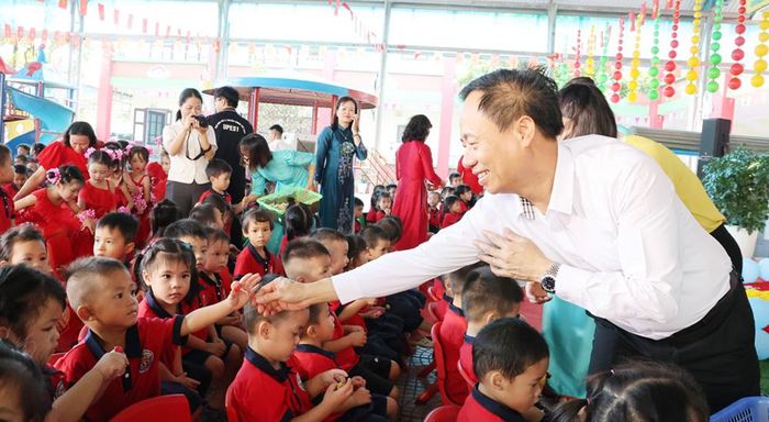  Đồng chí Đinh Đức Cảnh trao quà cho các cháu. 