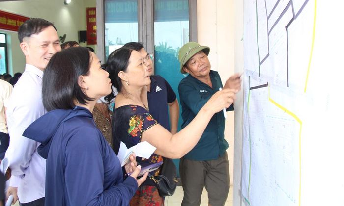  Người dân phấn khởi xác định lô đất của gia đình qua bản đồ quy hoạch khu tái định cư. 