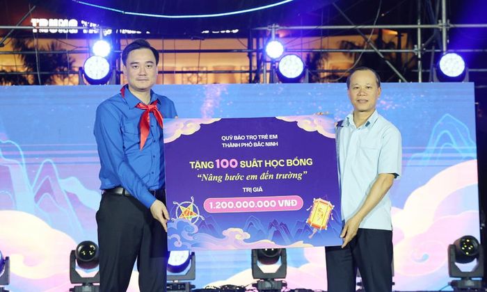  Đồng chí Mai Sơn trao biểu trưng kinh phí học bổng "Nâng bước em đến trường" cho lãnh đạo Thành đoàn.  