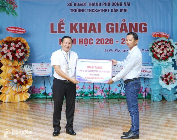 Lãnh đạo Trường THCS-THPT Đắk Mai (xã Bù Gia Mập) đại diện nhận bảng biểu trưng 10 bếp ăn do Công ty cổ phần Đầu tư hạ tầng Donacoop tài trợ cho các trường học ở các xã biên giới trên địa bàn thành phố, do Ủy ban MTTQ Việt Nam thành phố vận động tài trợ.