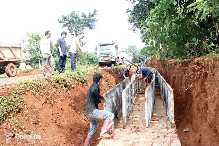 Công nhân thi công rãnh thoát nước của dự án sửa chữa, cải tạo một tuyến đường ở xã Thọ Sơn.