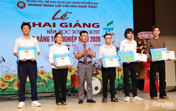 Phó Giám đốc Sở Văn hóa, Thể thao và Du lịch Nguyễn Khắc Vĩnh trao học bổng bán phần cho học sinh. Ảnh: My Ny