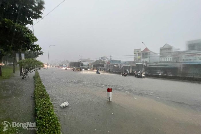 Đoạn quốc lộ 1, trước Bệnh viện Nhi đồng Đồng Nai, phường Tam Hiệp ngập khiến các phương tiện đi lại khó khăn. Ảnh: Lê Duy