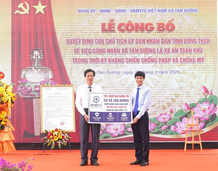Đại diện lãnh đạo Bảo hiểm xã hội tỉnh trao quyết định và biểu trưng 100% người dân thường trú trên địa bàn xã tham gia bảo hiểm y tế do ngân sách nhà nước hỗ trợ.