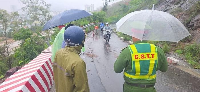  Lực lượng chức năng giăng dây và đặt biển cảnh báo khu vực sạt lở tại dốc Mộng Cầm. Ảnh: ĐVCC 
