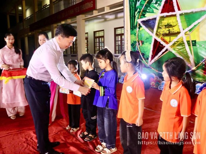 Đồng chí Đinh Hữu Học, Ủy viên Ban Thường vụ Tỉnh ủy, Phó Chủ tịch Thường trực UBND tỉnh tặng quà cho các em học sinh trên địa bàn xã