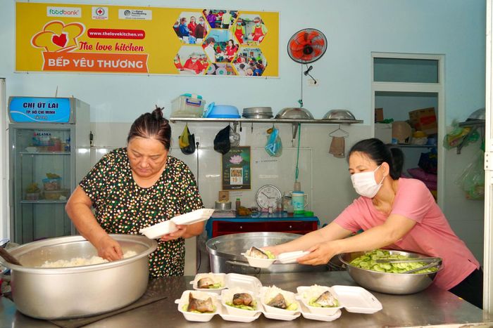 Bà Phạm Thị Yến (bìa trái) đang phân chia cơm
