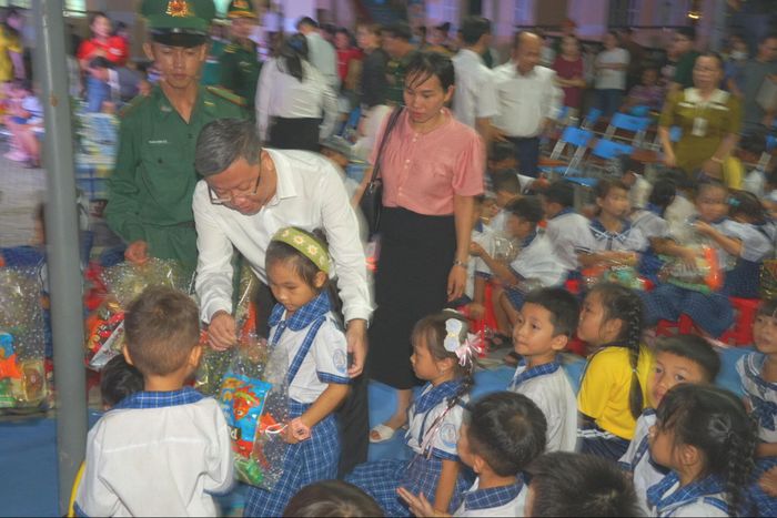 Đồng chí Nguyễn Đức Hải Tùng, Bí thư Đảng uỷ xã Hoà Thắng tặng quà cho các em học sinh