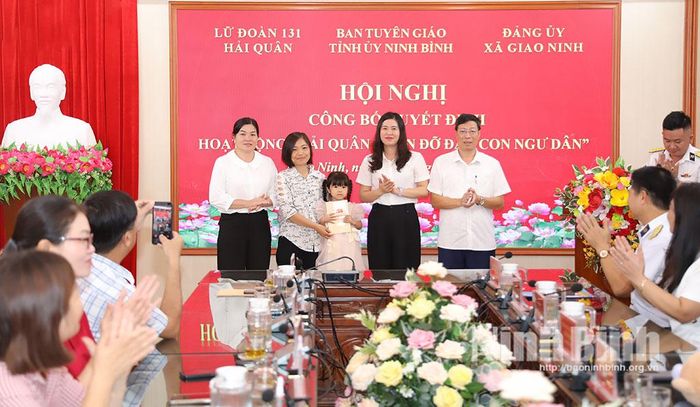 Lãnh đạo xã Giao Ninh trao tặng quà cho cháu Nguyễn Thị Kim Ngân.