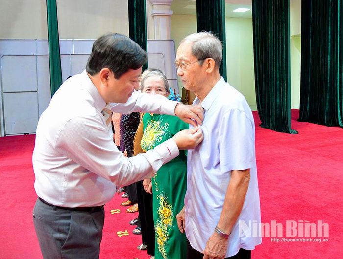 Đồng chí Lê Văn Kiên, Tỉnh ủy viên, Bí thư Đảng uỷ trao Huy hiệu Đảng cho đảng viên.