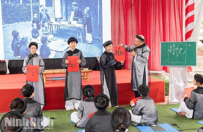Học sinh trải nghiệm viết thư pháp tại Đền thờ Trạng nguyên Nguyễn Hiền, xã Nam Hồng. Ảnh: Viết Dư