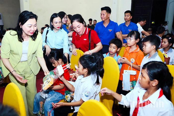 Đồng chí Đinh Thị Lụa, Phó Bí thư Tỉnh ủy, Chủ tịch Ủy ban MTTQ Việt Nam tỉnh tặng quà cho các em thiếu nhi tham dự chương trình.
