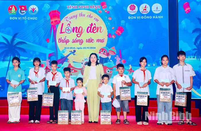Đồng chí Đinh Thị Lụa, Phó Bí thư Tỉnh ủy, Chủ tịch Ủy ban MTTQ Việt Nam tỉnh trao tặng quà cho các em thiếu nhi có hoàn cảnh khó khăn trên địa bàn tỉnh.