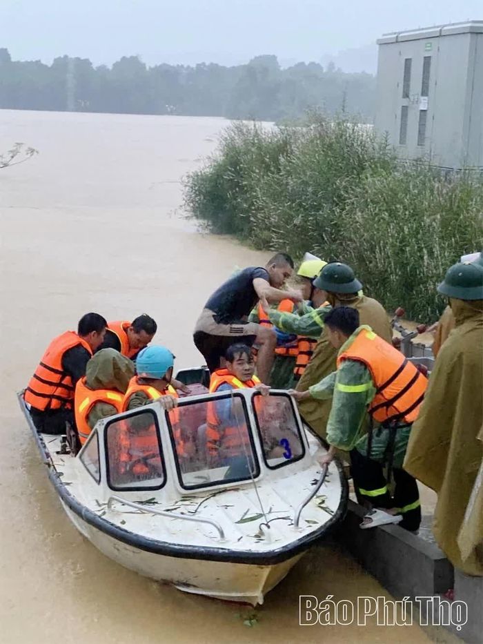 Lực lượng chức năng hỗ trợ người dân xã An Nghĩa sơ tán khi nước sông Bôi dâng cao.