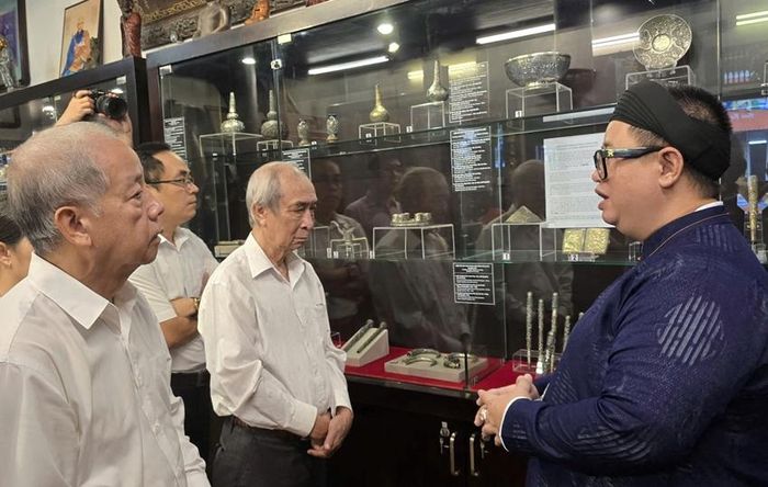 Nhà sưu tập Lê Gia (áo dài xanh) chia sẻ về các hiện vật trong bộ sưu tập.