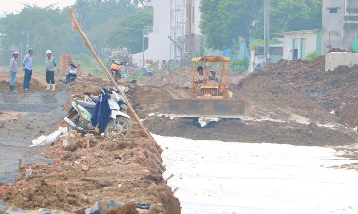 Cạnh đó một nhóm khác đang đào đắp, xử lý nền đất yếu.