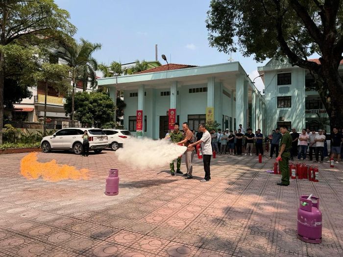 Cán bộ Đội CC&CNCH khu vực số 19, Phòng Cảnh sát PCCC và CNCH (Công an TP Hà Nội) hướng dẫn kỹ năng sử dụng phương tiện chữa cháy ban đầu cho người dân xã Bát Tràng. (Ảnh: Công an TP Hà Nội).