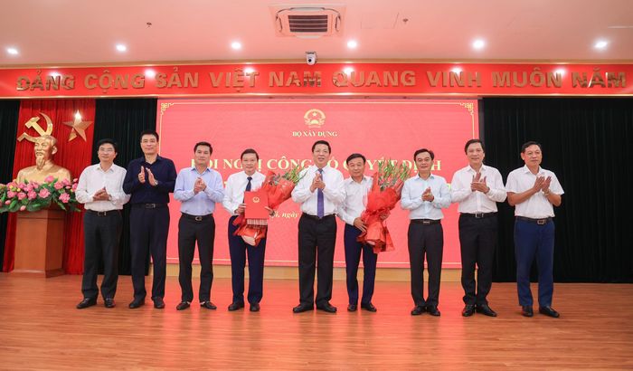 Lãnh đạo Bộ Xây dựng và các đại biểu tặng hoa chúc mừng đồng chí Nguyễn Danh Huy và đồng chí Lê Hồng Vinh. (Ảnh: Tạ Hải).