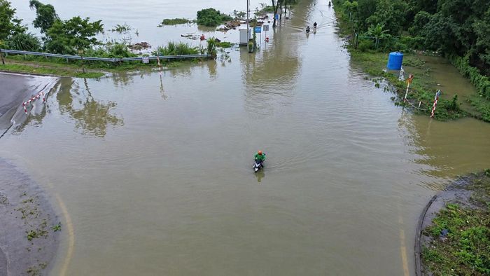 Nhiều vị trí trũng thấp chìm trong nước, khiến phương tiện khó lưu thông, một số xe máy cố vượt qua bị chết máy, người dân phải dắt xe hoặc quay đầu tìm hướng khác.