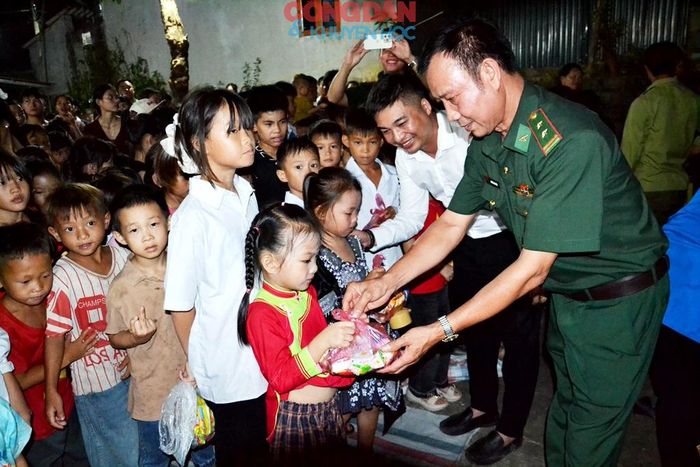 Chỉ huy Đồn Biên phòng Bản Lầu trao quà cho các cháu học sinh. Ảnh: Quốc Hồng