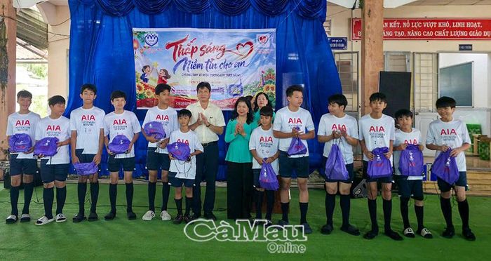 Ông Đặng Trí Thủ, Phó Giám đốc Sở Giáo dục và Đào tạo cùng bà Lê Tuyết Mai, Phó Chủ tịch Hội Bảo vệ quyền trẻ em Việt Nam, trao bộ đồ thể thao cho các em.