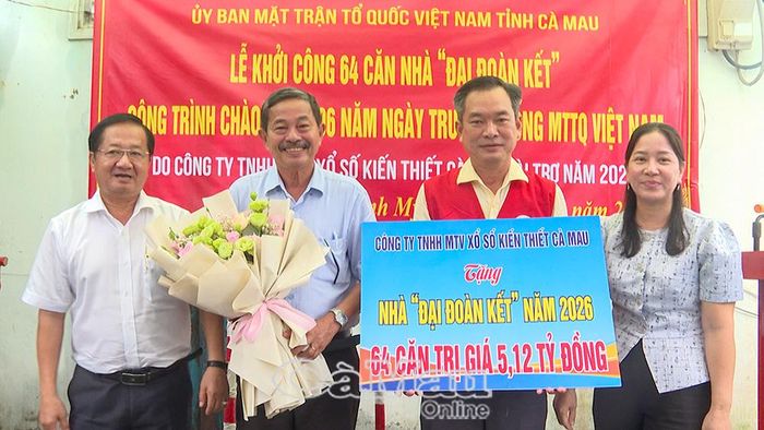 Phó Chủ tịch Thường trực Uỷ ban MTTQ Việt Nam tỉnh Cà Mau Lê Thanh Triều (bìa trái) trao hoa cảm ơn ông Lê Thanh Hải, Chủ tịch Công ty TNHH MTV Xổ số kiến thiết Cà Mau, hỗ trợ kinh phí xây dựng 64 căn nhà Đại đoàn kết.