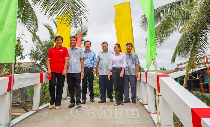 Ông Lâm Văn Đoàn, Phó Bí thư Thường trực Đảng uỷ xã Tân Lộc (thứ ba từ trái sang), cùng các đại biểu phấn khởi đi trên cầu giao thông nông thôn tại ấp Kênh Ngang vừa được khánh thành.