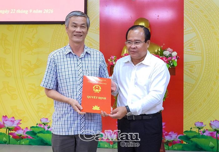 Phó Chủ tịch UBND tỉnh Nguyễn Minh Luân trao quyết định nghỉ hưu theo chế độ cho ông Trần Quang Khoá, Phó Giám đốc Sở Y tế. Ảnh: BÍCH NGỌC
