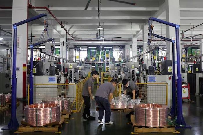 Công nhân di chuyển các cuộn thanh đồng trên dây chuyền sản xuất tại nhà máy Wellascent ở Ganzhou, tỉnh Giang Tây, Trung Quốc, ngày 14/8/2025. Ảnh: Florence Lo/Reuters.