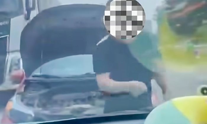 Ông N.V.T. mở nắp capo và dùng điện thoại ghi hình lại tài xế của chiếc xe đang đi đúng phần đường. (Ảnh: Chụp màn hình)