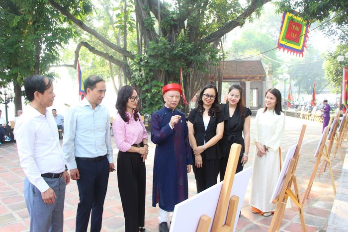 Nhân dân phường Giảng Võ tìm hiểu về lịch sử văn hóa của đền Voi Phục thông qua trưng bày ảnh tại lễ hội. Ảnh: MH