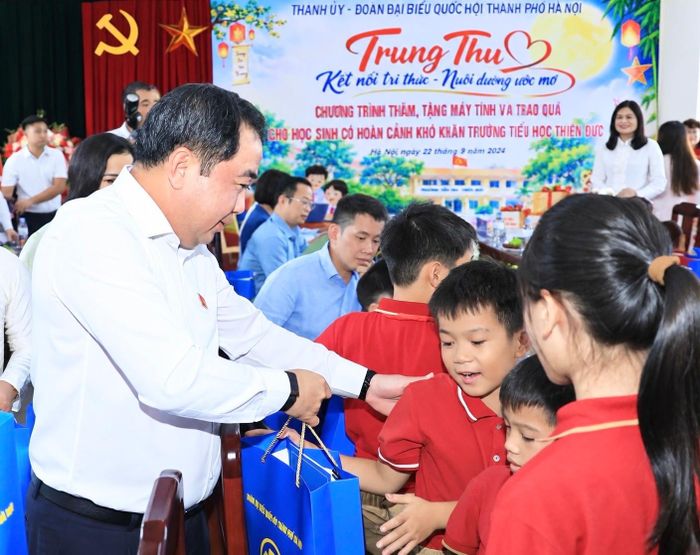 Bí thư Thành ủy Hà Nội Trần Đức Thắng trao quà tặng học sinh Trường Tiểu học Thiên Đức. Ảnh: Quang Thái