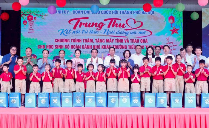 Bí thư Thành ủy Hà Nội Trần Đức Thắng và các đại biểu Quốc hội cùng các đồng chí lãnh đạo thành phố Hà Nội trao quà tặng học sinh Trường Tiểu học Thiên Đức. Ảnh: Quang Thái